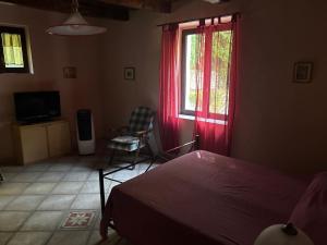 a bedroom with a bed and a window with red curtains at Palazzo giallo, appartamento nel centro storico nel cuore del Pollino in Morano Calabro