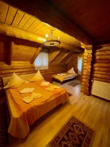 a bedroom with a bed in a log cabin at Cabana Wiarusti in Moieciu de Sus