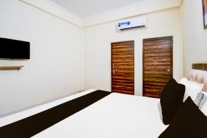 a bedroom with a bed and a flat screen tv at OYO Flagship hotel vasundhara inn in Lucknow
