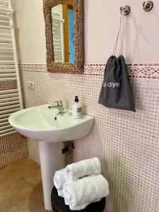 a bathroom with a sink and a mirror and towels at Casa El Colibrí in Villafranca del Bierzo +14 photos