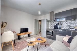 a living room with a couch and a kitchen at Le Perroquet - Parking - Campus in Saint-Martin-dʼHères