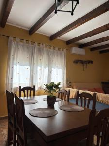 a dining room with a wooden table and chairs at Casa Rural Las Nogueras in Caserío Arroyofrío +27 photos