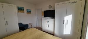 a bedroom with a bed and a flat screen tv at Himmel & Meer Suite in Timmendorfer Strand