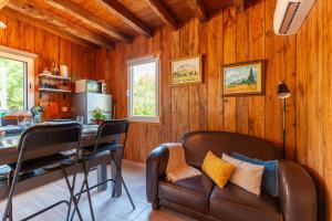 a living room with a leather couch and a table at Le Chalet Des Oliviers in Roquefort-la-Bédoule