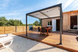 a wooden deck with a table and chairs on it at Le Chalet Des Oliviers in Roquefort-la-Bédoule +12 photos