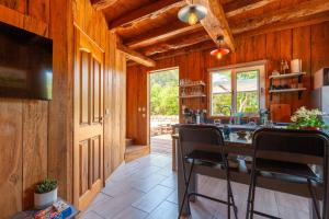 a kitchen with wooden walls and a table with chairs at Le Chalet Des Oliviers in Roquefort-la-Bédoule