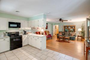 Una cocina con gabinetes blancos y una sala de estar. en 2 Mi to Square, 3 Mi to Ole Miss Oxford Getaway!, en Oxford