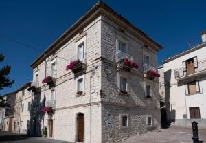 a large stone building with flowers on the balconies at La Dimora di Pindaro in Colledimacine
