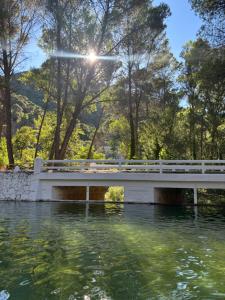 a bridge over a river with trees in the background at Casa Rural Las Nogueras in Caserío Arroyofrío