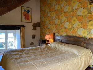 a bedroom with a bed with a floral wall at 212 -Maison de caractère 10p entre Erquy et Frehel in Plurien