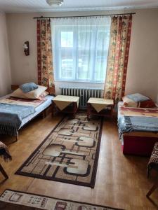 a room with three beds and a window and a rug at Sielankowy Domek in Istebna