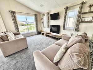 a living room with a couch and a tv at Seaside Escape - Parkdean Resort Camber Sands in Camber