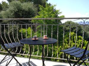 una mesa y sillas en un balcón con 2 tazas en Superbe haut de villa, en La Seyne-sur-Mer