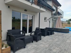 Eine Gruppe von Stühlen steht auf einer Terrasse in der Unterkunft Villa REST & SPA in Zbiczno