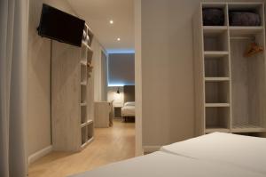 Un dormitorio con una cama y un televisor en una pared. en Hostal Bcn 46, en Barcelona
