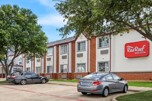 尤利斯Red Roof Inn & Suites Euless - DFW Airport Southwest的两辆汽车停在红岩旅馆前的停车场