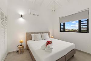 a white bedroom with a large bed with flowers on it at Tropical Escape - CBW366 - 8 in Jan Thiel