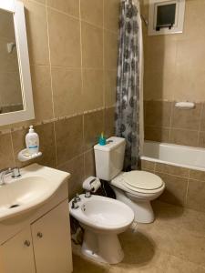 ein Badezimmer mit Toilette, Waschbecken und Dusche in der Unterkunft Francia Apartment in Rosario