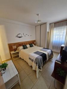 ein Schlafzimmer mit einem Bett, einem Tisch und einem Fernseher in der Unterkunft Francia Apartment in Rosario