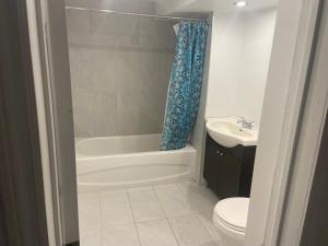 a bathroom with a tub and a toilet and a sink at Résidence le HAvre in Laval