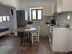 a kitchen with a table and a small kitchen with a refrigerator at Kalithea Chorio 2 in Angathiás