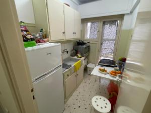 a kitchen with a white refrigerator and a sink at Loutraki, Poseidonos seaside Apartments in Loutraki