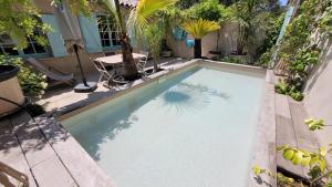 een zwembad met een palmboom erin bij Larimar Etablissement- 200 M de la mer in Sainte-Maxime