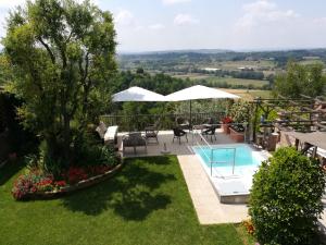 a garden with a pool and a table and chairs at Cà Nostra B&B Home Restaurant in Portacomaro