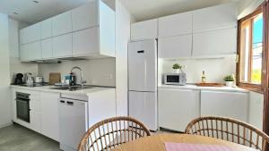 a kitchen with white cabinets and a table and chairs at Aguaviva apartment in Callao Salvaje