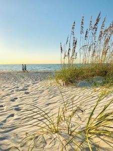 two people walking on the beach near the ocean at Sanibel Siesta on the Beach in Sanibel