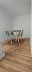 una mesa y sillas en una habitación con suelo de madera en InBerna, en Peniche 12 fotos más