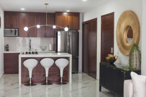 a kitchen with a kitchen island with white counter tops at Modern 2BR Ocean view - Walk to Beach and Downtown in Puerto Vallarta