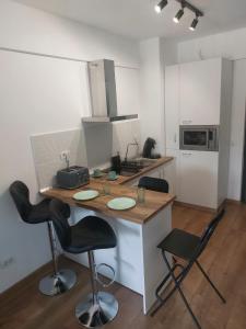 a kitchen with a counter with two chairs and a table at Studio Andrew in Saturn