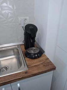 a coffee maker sitting on a counter next to a sink at Studio Andrew in Saturn +14 photos
