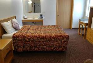 a hotel room with a bed and a sink at Guardian Inn in Le Center +3 photos