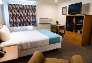 a hotel room with a bed and a television at Guardian Inn in Le Center