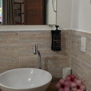 a white sink in a bathroom with pink flowers at Pousada Vila Icaraí in Icaraí +45 photos