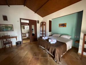 a bedroom with a bed and a chair in a room at Pousada Vila Icaraí in Icaraí