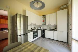 a kitchen with white cabinets and a stainless steel refrigerator at Casa Laghi del Barro in Galbiate