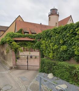 an ivy covered building with a gate and a lighthouse at Le belvédère au cœur de Saverne in Saverne
