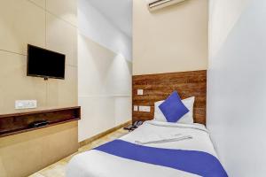 a bedroom with a bed and a tv on a wall at Hotel Karpagam Lodging House Nr Railway Station & Gandhipuram bus stand in Coimbatore
