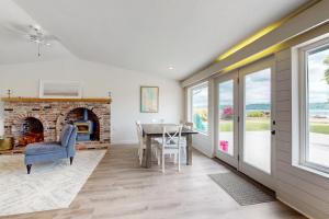 a dining room with a brick fireplace and a table at Belfair Bliss in Belfair