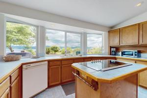 a kitchen with wooden cabinets and a large window at Belfair Bliss in Belfair +15 photos