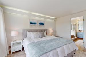 a white bedroom with a large bed and two lamps at Belfair Bliss in Belfair