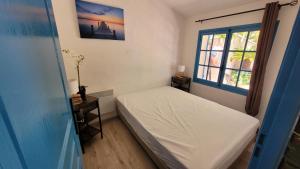 een kleine slaapkamer met een bed en een raam bij Larimar Etablissement- 200 M de la mer in Sainte-Maxime +19 foto's