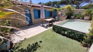 een achtertuin met een zwembad en een tafel bij Larimar Etablissement- 200 M de la mer in Sainte-Maxime