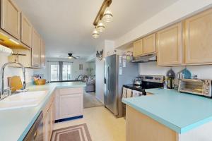 a kitchen with blue countertops and a stainless steel refrigerator at Bethany Marina --- 38249 Yacht Basin Rd #22 in Ocean View