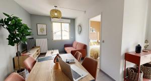 un salon avec une table avec un ordinateur portable dessus dans l'établissement Les Tilleuls I, à Villeurbanne