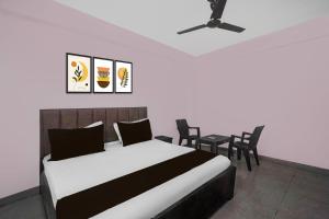 a bedroom with a bed and a table and chairs at Hotel O Shree Shyam Guest House in Noida