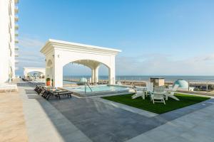 eine Terrasse mit Pool, Stühlen und Meerblick in der Unterkunft Emerald by the Sea #711 in Galveston